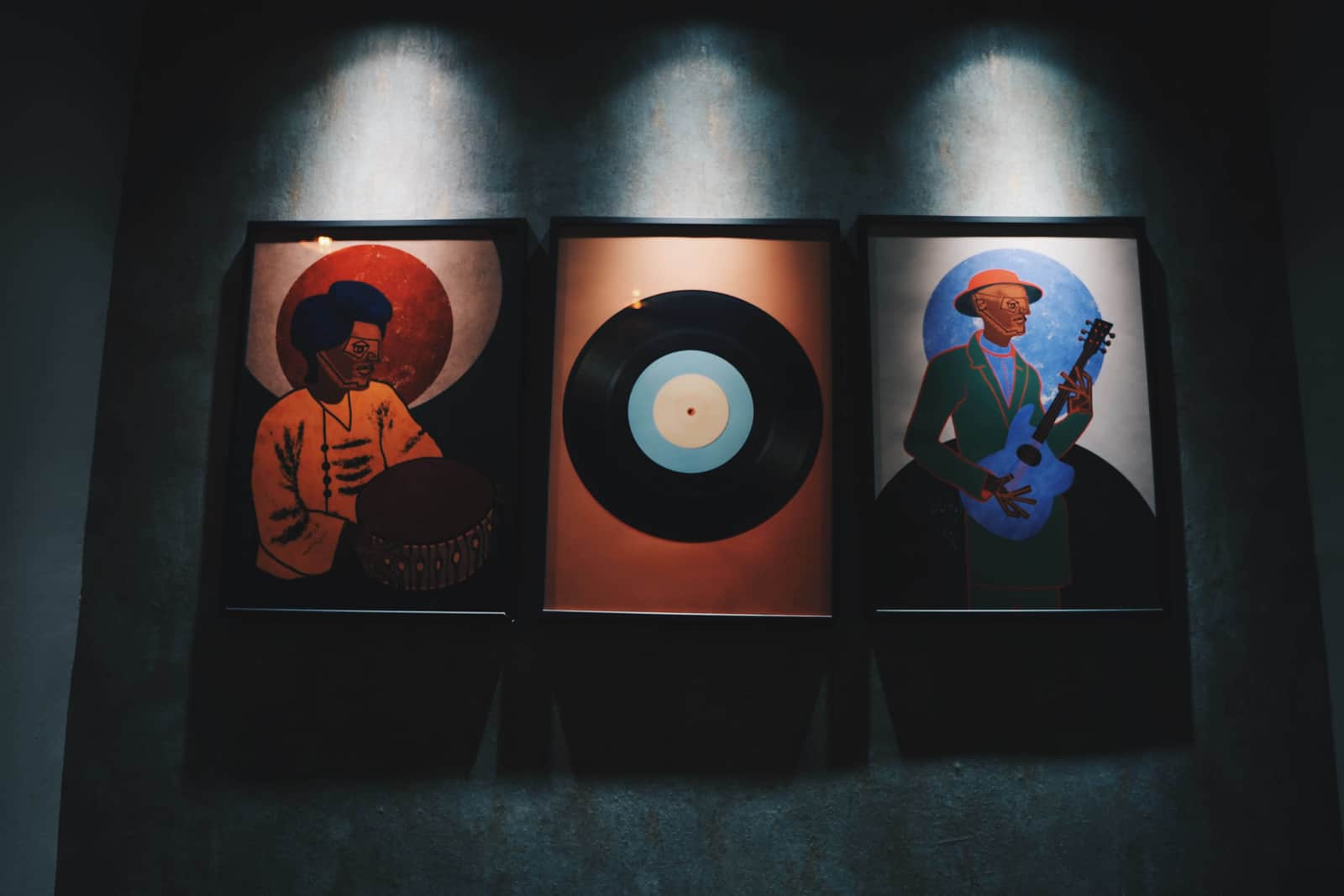 Tres cuadros de música y vinilo en la pared de Licensed Coffee en Madrid