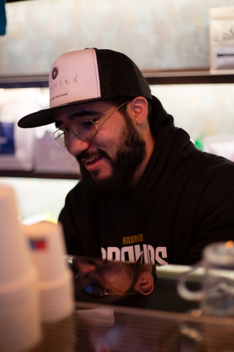 David Edson, founder of Licensed Coffee, behind the bar in a Licensed Coffee branded cap